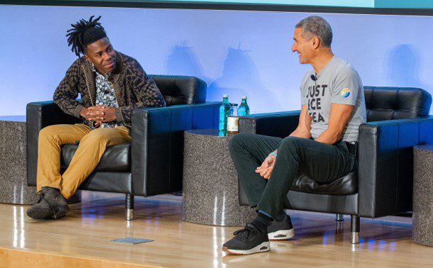 A man sitting on top of a couch next to another man.