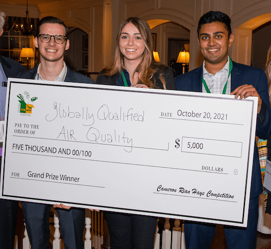 Three people holding a giant check in front of them.
